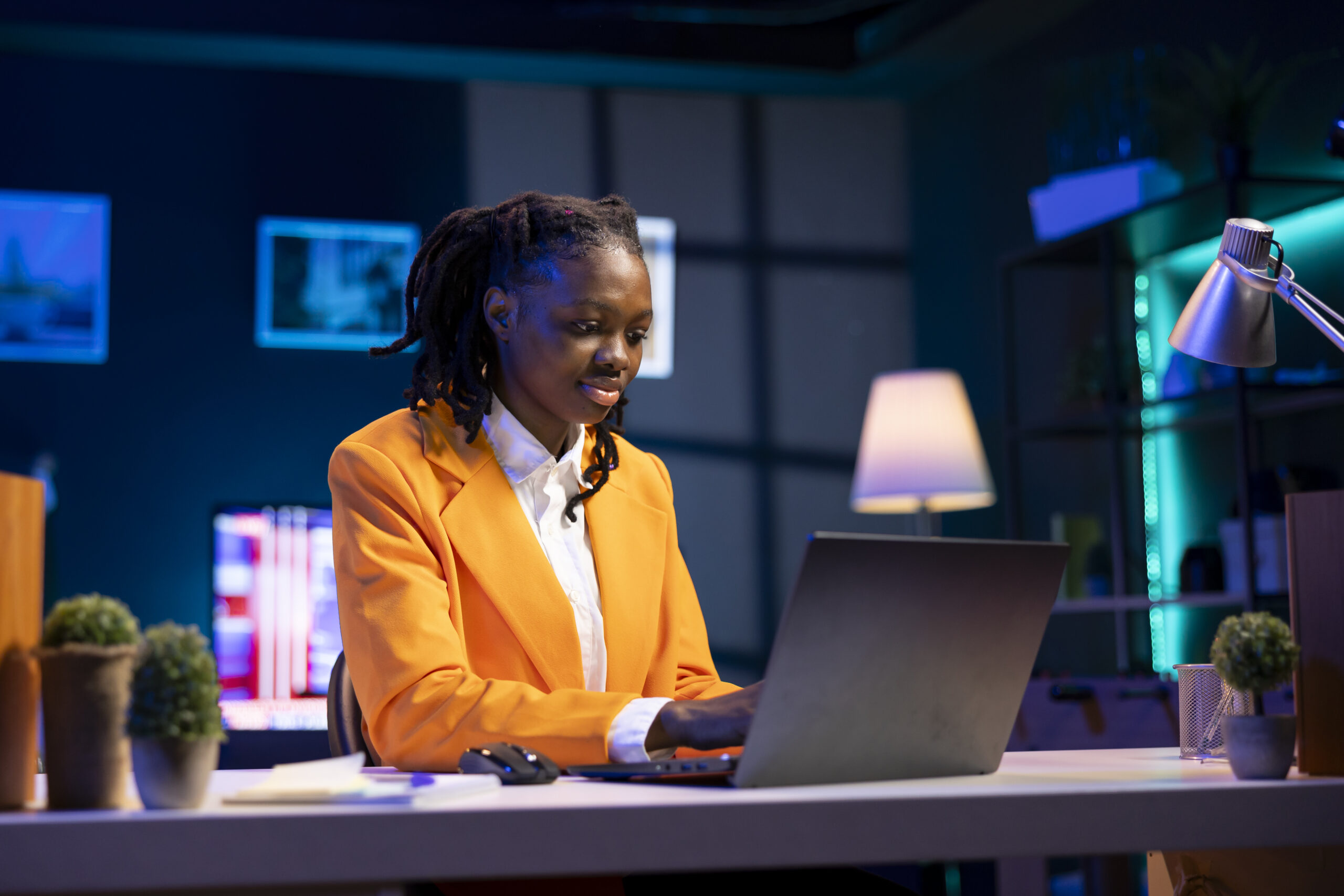 Freelancer at desk working from home in apartment office Freelancer at desk working from home in apartment office solving business related tasks on laptop. Remote employee sitting down in living room, sending emails on notebook